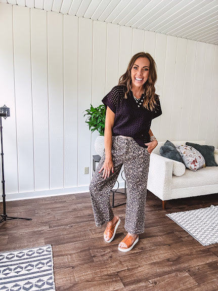 Stretchy camel colored leopard print barrel pants with side pockets, tan trim at the waist, button and zipper closure and relaxed fit.