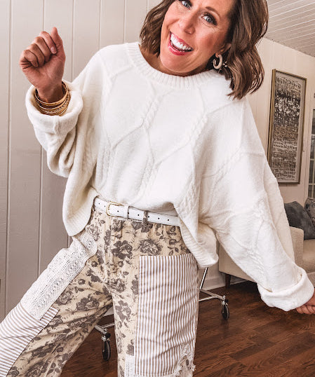 khaki and grey floral denim wide leg pants with an elastic waist, paired with delicate crochet lace and khaki striped patches with a button and zipper closure.
