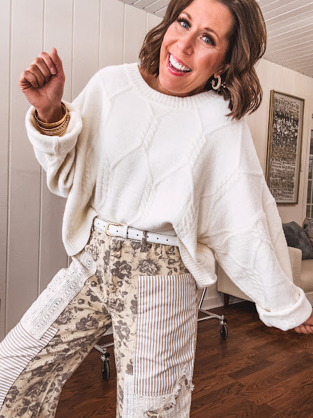 khaki and grey floral denim wide leg pants with an elastic waist, paired with delicate crochet lace and khaki striped patches with a button and zipper closure.