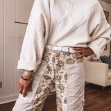 khaki and grey floral denim wide leg pants with an elastic waist, paired with delicate crochet lace and khaki striped patches with a button and zipper closure.
