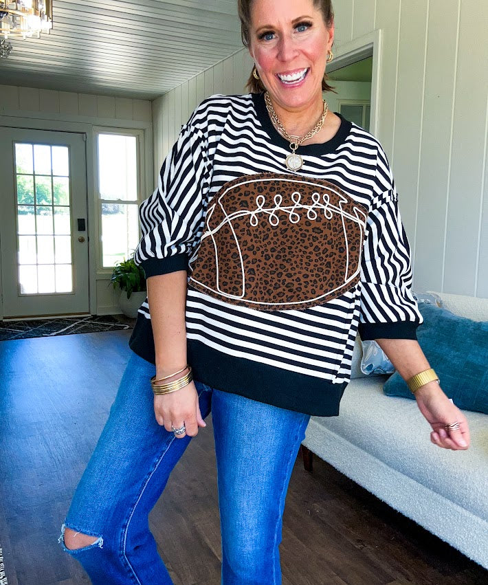 Soft, terry-like black and white striped half sleeve top with oversized leopard print football applique on the front, black trim at the round neck, cuffs and wide hem.