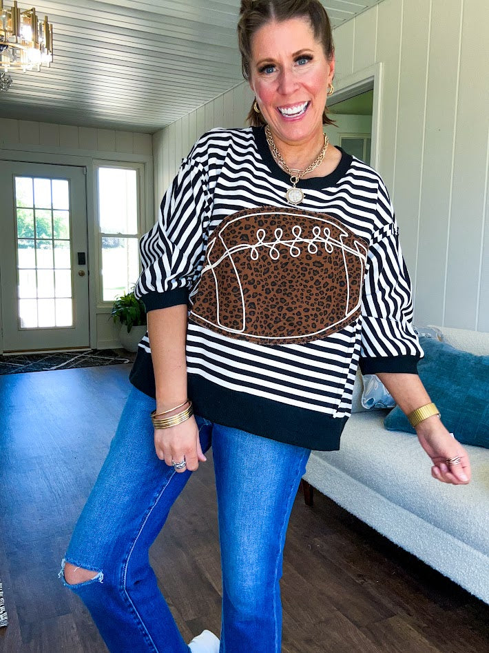 Soft, terry-like black and white striped half sleeve top with oversized leopard print football applique on the front, black trim at the round neck, cuffs and wide hem.