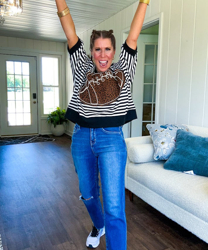 Soft, terry-like black and white striped half sleeve top with oversized leopard print football applique on the front, black trim at the round neck, cuffs and wide hem.