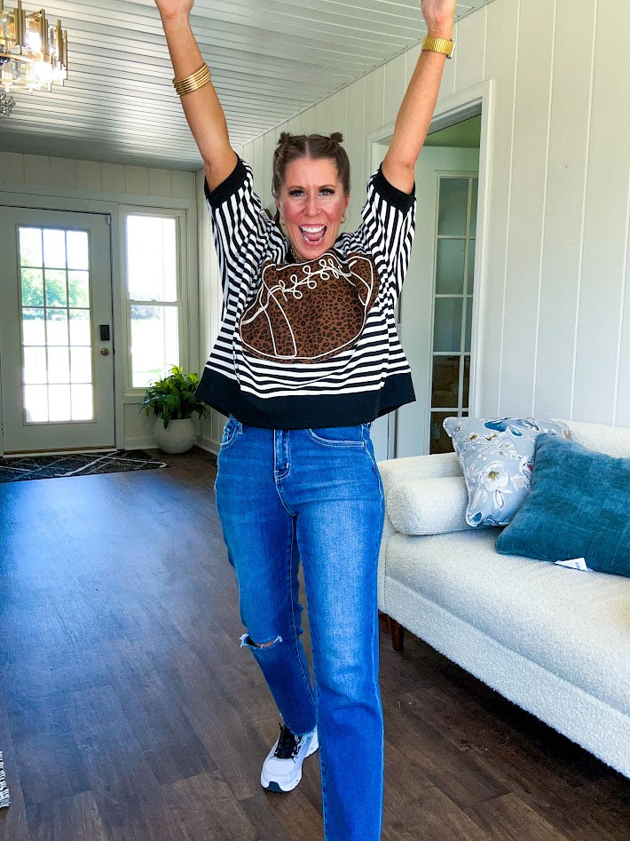 Soft, terry-like black and white striped half sleeve top with oversized leopard print football applique on the front, black trim at the round neck, cuffs and wide hem.