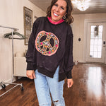 Washed charcoal pullover with exposed seams, a coral and floral peace patch on the front and split front hem.