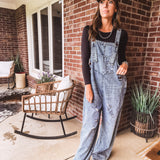 Loose fit medium wash denim overalls with adjustable button straps and sides and distressing throughout.