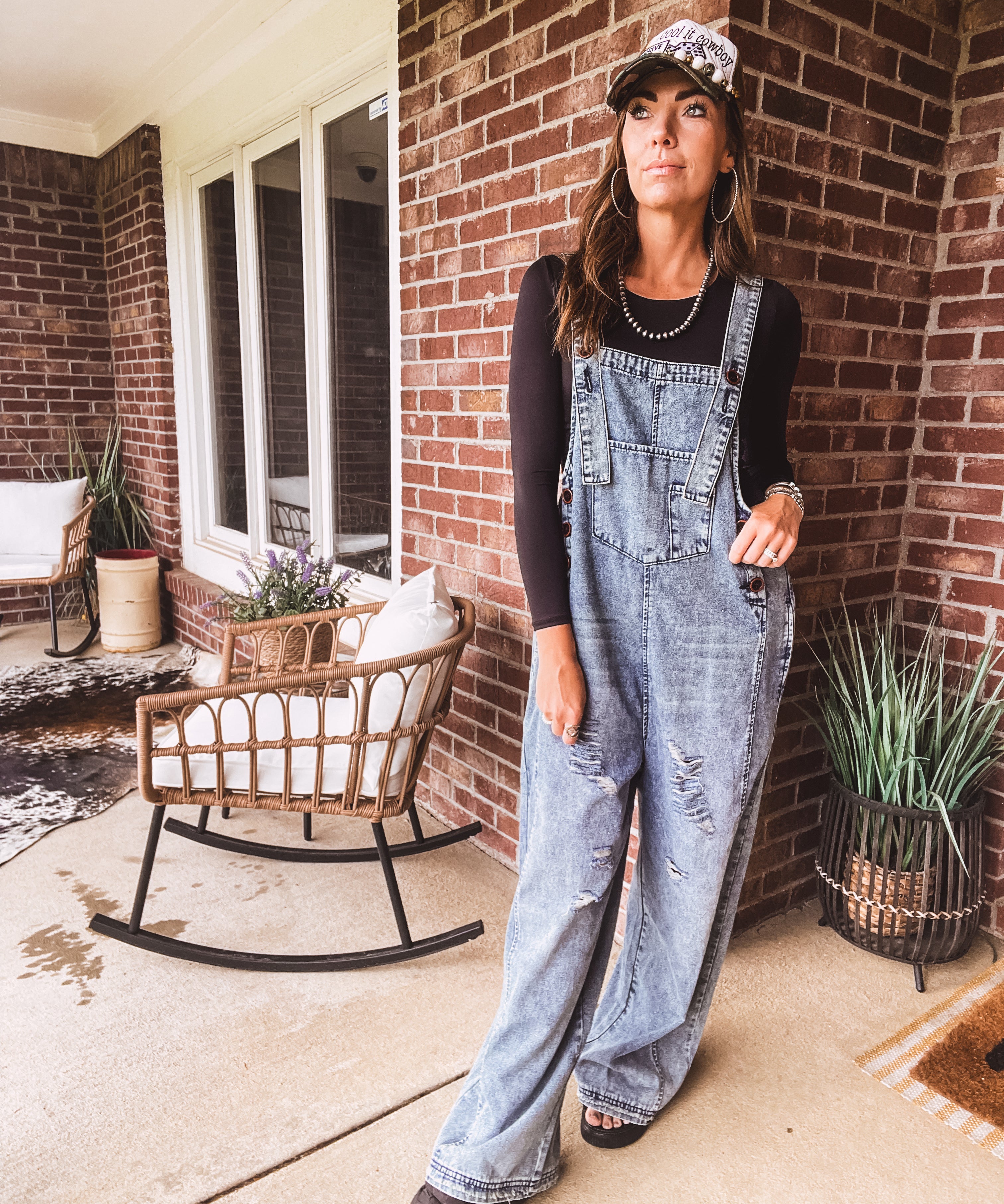 Loose fit medium wash denim overalls with adjustable button straps and sides and distressing throughout.