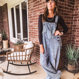 Loose fit medium wash denim overalls with adjustable button straps and sides and distressing throughout.