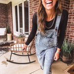 Loose fit medium wash denim overalls with adjustable button straps and sides and distressing throughout.