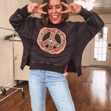 Washed charcoal pullover with exposed seams, a coral and floral peace patch on the front and split front hem.
