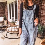 Loose fit medium wash denim overalls with adjustable button straps and sides and distressing throughout.