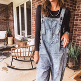 Loose fit medium wash denim overalls with adjustable button straps and sides and distressing throughout.