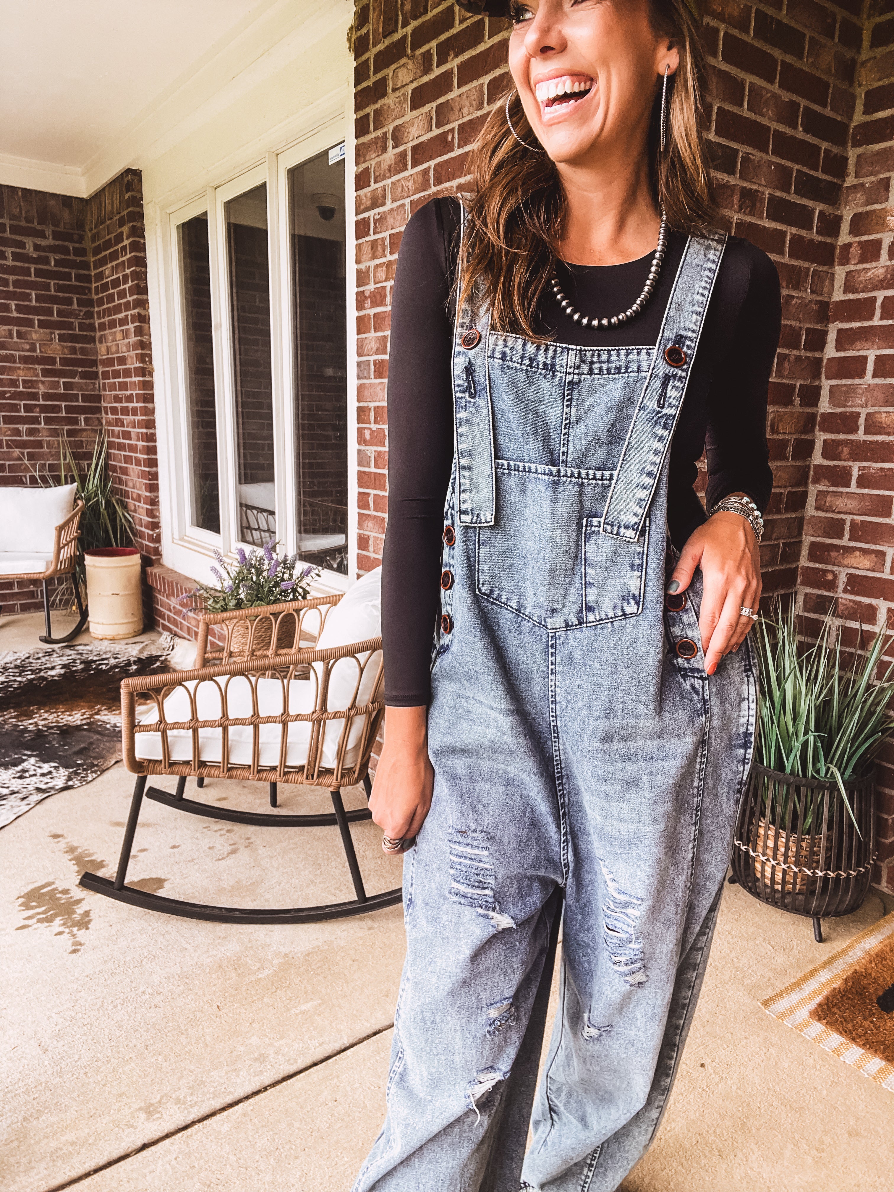 Loose fit medium wash denim overalls with adjustable button straps and sides and distressing throughout.