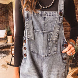 Loose fit medium wash denim overalls with adjustable button straps and sides and distressing throughout.