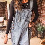 Loose fit medium wash denim overalls with adjustable button straps and sides and distressing throughout.