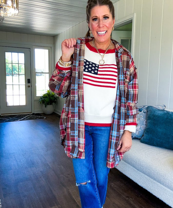 Cream long sleeved sweater with round neck and red trim at neck an cuffs with American Flag motif.