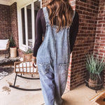 Loose fit medium wash denim overalls with adjustable button straps and sides and distressing throughout.