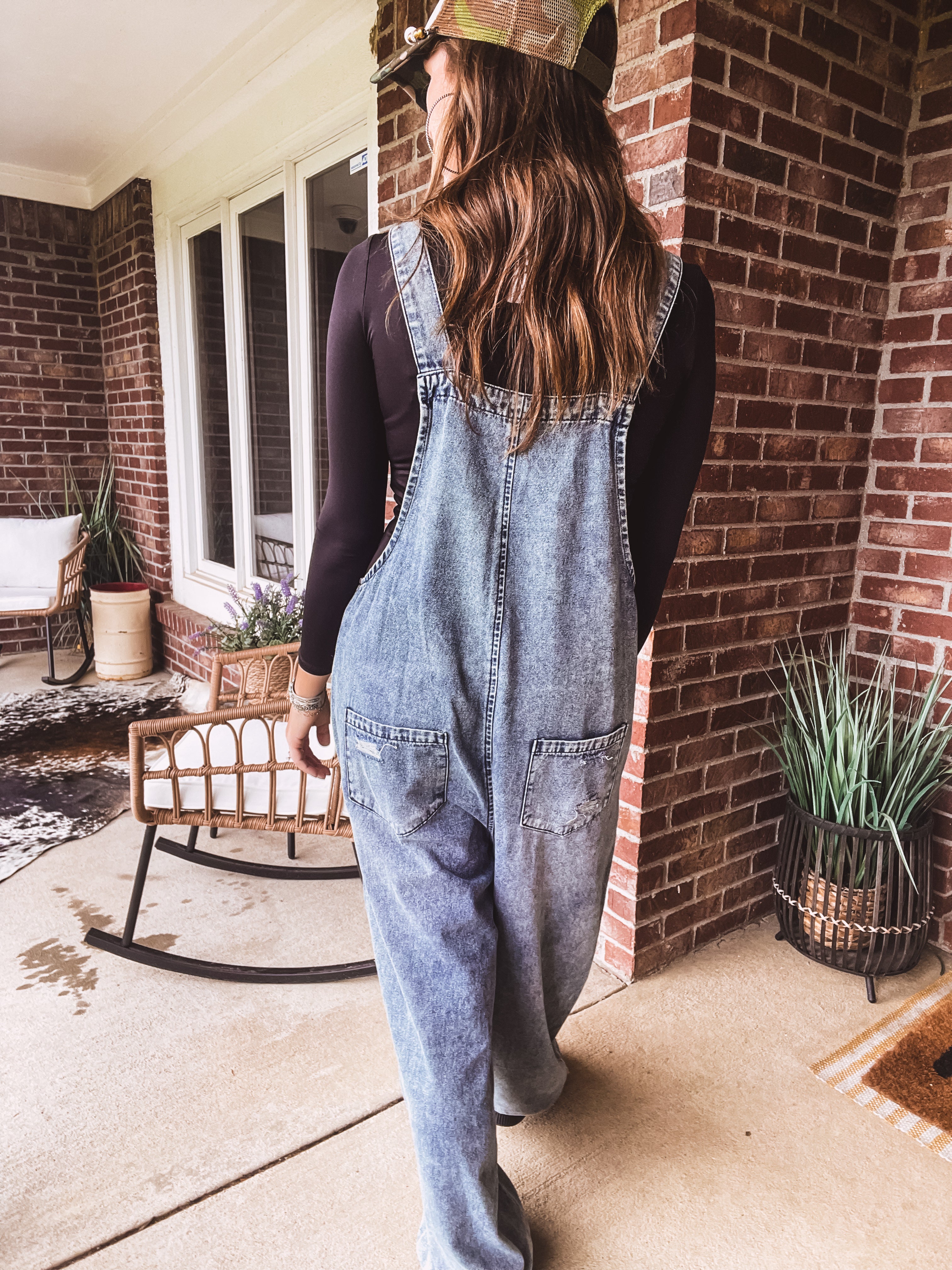 Loose fit medium wash denim overalls with adjustable button straps and sides and distressing throughout.