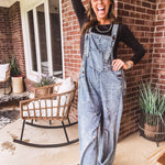 Loose fit medium wash denim overalls with adjustable button straps and sides and distressing throughout.