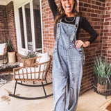 Loose fit medium wash denim overalls with adjustable button straps and sides and distressing throughout.