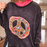Washed charcoal pullover with exposed seams, a coral and floral peace patch on the front and split front hem.