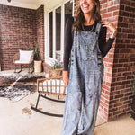 Loose fit medium wash denim overalls with adjustable button straps and sides and distressing throughout.