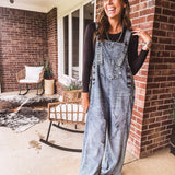 Loose fit medium wash denim overalls with adjustable button straps and sides and distressing throughout.