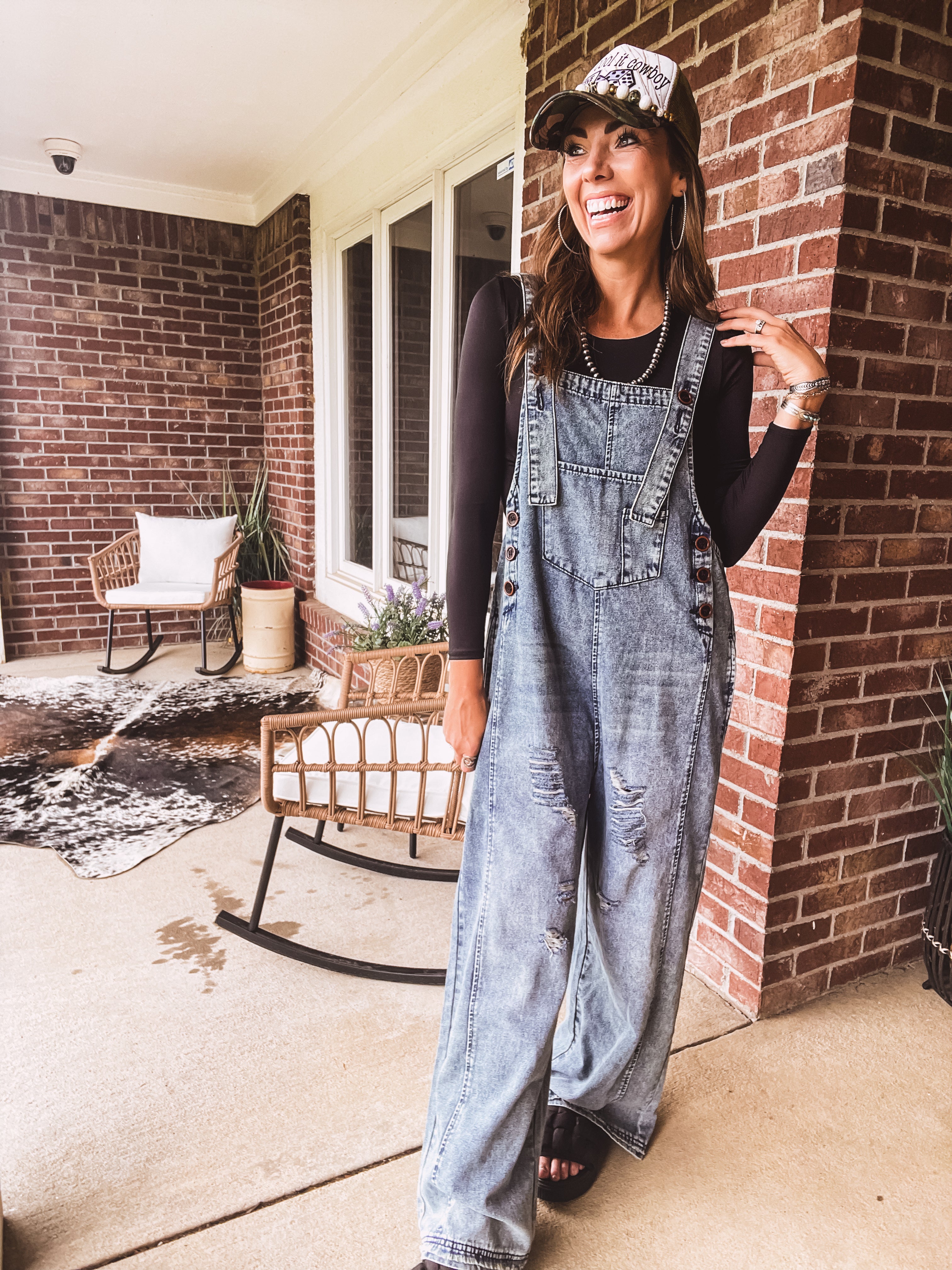 Loose fit medium wash denim overalls with adjustable button straps and sides and distressing throughout.