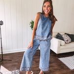 Light wash denim set that's equal parts effortless and eye-catching. The tank features a hook-and-eye neck closure and loose hem, while caramel embroidered stitching adds personality throughout. Pair it with the matching wide-leg pants—complete with button-zip closure, elastic back waist, front and side pleating, and pockets lined with the same playful embroidered detail.