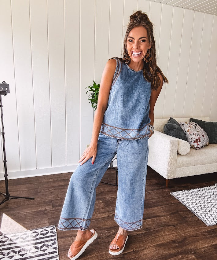 Light wash denim set that's equal parts effortless and eye-catching. The tank features a hook-and-eye neck closure and loose hem, while caramel embroidered stitching adds personality throughout. Pair it with the matching wide-leg pants—complete with button-zip closure, elastic back waist, front and side pleating, and pockets lined with the same playful embroidered detail.