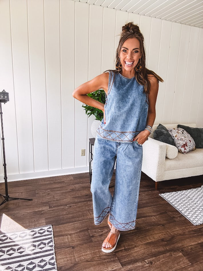 Light wash denim set that's equal parts effortless and eye-catching. The tank features a hook-and-eye neck closure and loose hem, while caramel embroidered stitching adds personality throughout. Pair it with the matching wide-leg pants—complete with button-zip closure, elastic back waist, front and side pleating, and pockets lined with the same playful embroidered detail.