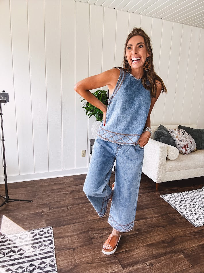 Light wash denim set that's equal parts effortless and eye-catching. The tank features a hook-and-eye neck closure and loose hem, while caramel embroidered stitching adds personality throughout. Pair it with the matching wide-leg pants—complete with button-zip closure, elastic back waist, front and side pleating, and pockets lined with the same playful embroidered detail.