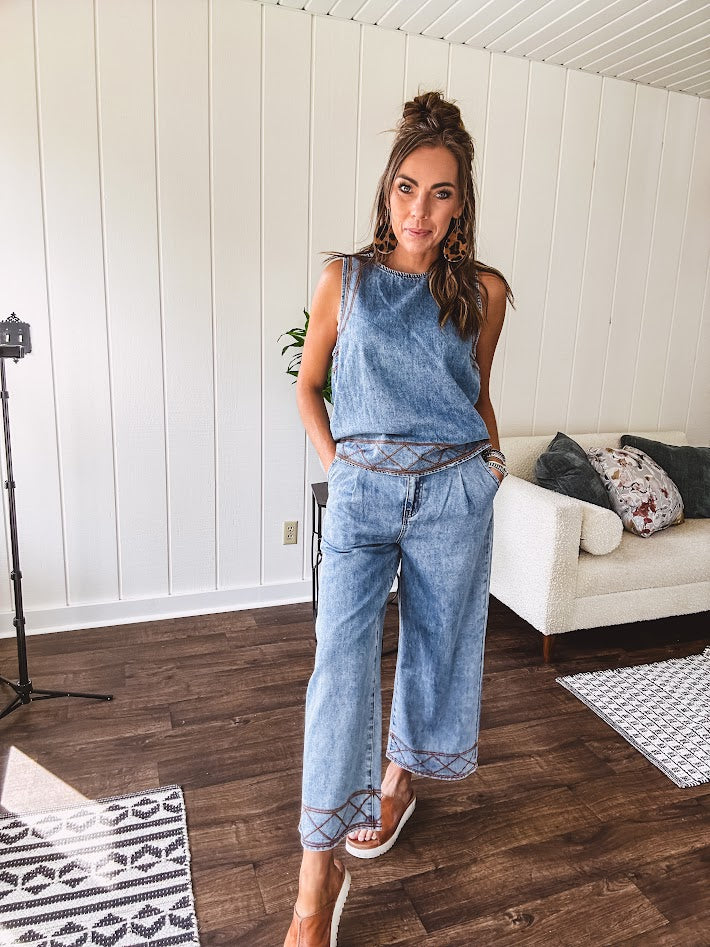 Light wash denim set that's equal parts effortless and eye-catching. The tank features a hook-and-eye neck closure and loose hem, while caramel embroidered stitching adds personality throughout. Pair it with the matching wide-leg pants—complete with button-zip closure, elastic back waist, front and side pleating, and pockets lined with the same playful embroidered detail.
