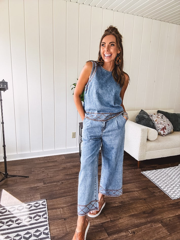 Light wash denim set that's equal parts effortless and eye-catching. The tank features a hook-and-eye neck closure and loose hem, while caramel embroidered stitching adds personality throughout. Pair it with the matching wide-leg pants—complete with button-zip closure, elastic back waist, front and side pleating, and pockets lined with the same playful embroidered detail.