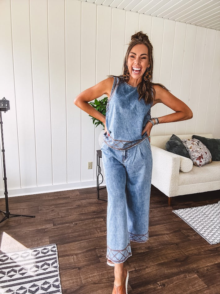 Light wash denim set that's equal parts effortless and eye-catching. The tank features a hook-and-eye neck closure and loose hem, while caramel embroidered stitching adds personality throughout. Pair it with the matching wide-leg pants—complete with button-zip closure, elastic back waist, front and side pleating, and pockets lined with the same playful embroidered detail.