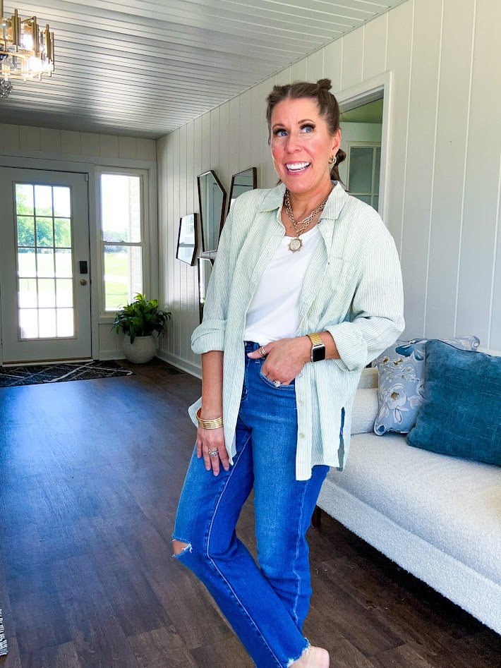 Thin, lightweight button down long sleeved top with classic collar and abalone buttons, front pocket in light green and white mini stripe.