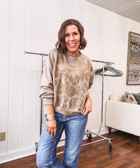 Taupe crew neck pullover with matching floral embroidery on the front.