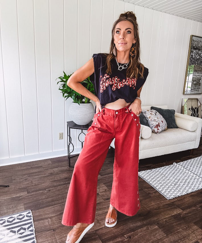 These vintage-inspired wide leg pants are a total vibe—low-rise silhouette with playful silver eyelets and studs running down the sides that catch the light just right. Crafted from lightweight 100% cotton denim with that perfect worn-in wash. The button and zipper closure with elastic back waist keeps them comfortable all day long. Ultra-wide legs that make a statement.