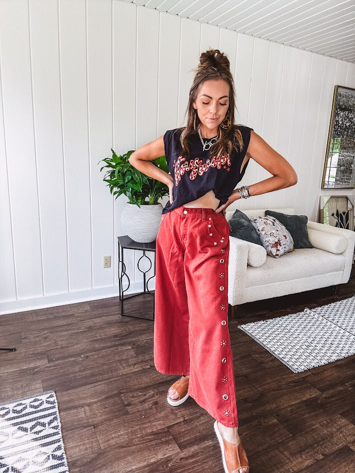 These vintage-inspired wide leg pants are a total vibe—low-rise silhouette with playful silver eyelets and studs running down the sides that catch the light just right. Crafted from lightweight 100% cotton denim with that perfect worn-in wash. The button and zipper closure with elastic back waist keeps them comfortable all day long. Ultra-wide legs that make a statement.