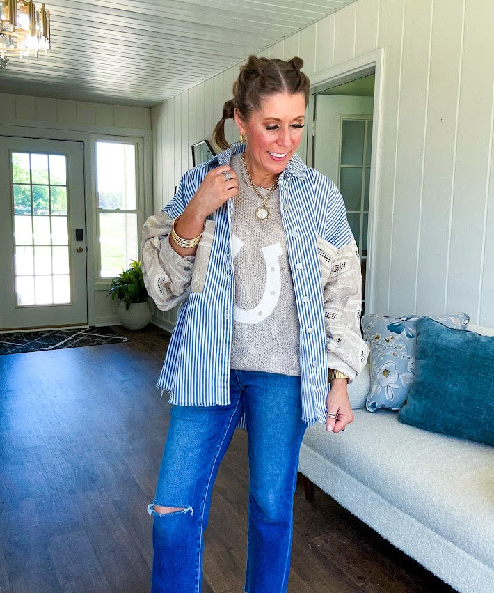Nearly sheer open weave taupe woven sweater vest with fleece ivory horseshoe applique on the front, round neck, relaxed fit.