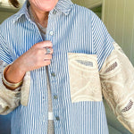 White and denim striped long sleeved shacket with silver button front, collar and taupe and lace sleeves and front pocket.