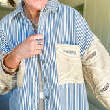 White and denim striped long sleeved shacket with silver button front, collar and taupe and lace sleeves and front pocket.