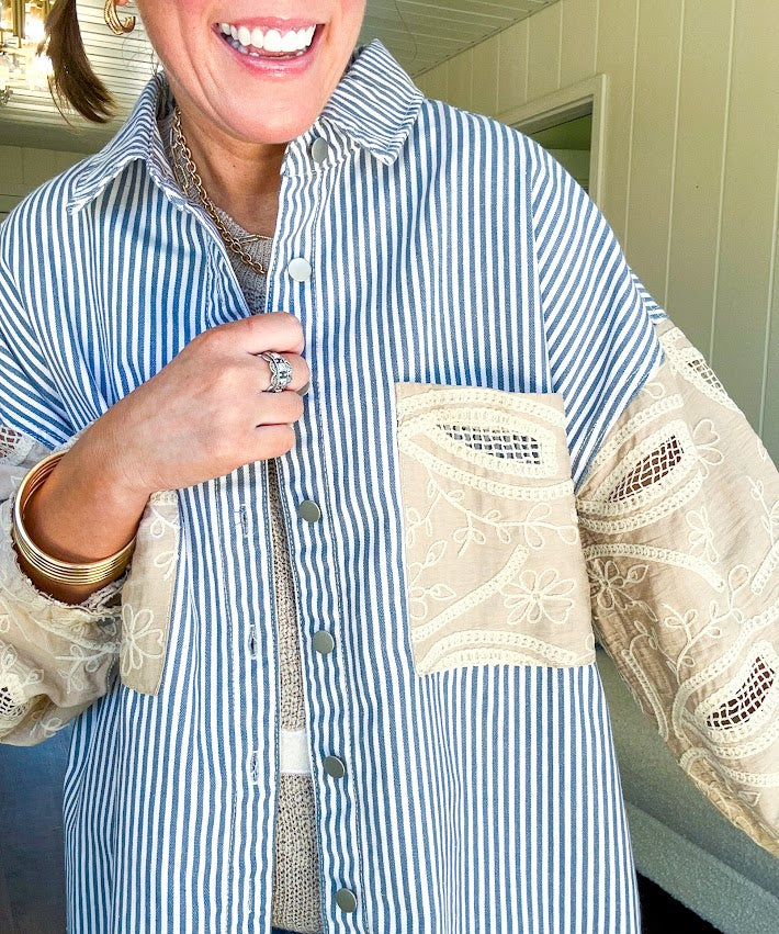 White and denim striped long sleeved shacket with silver button front, collar and taupe and lace sleeves and front pocket.