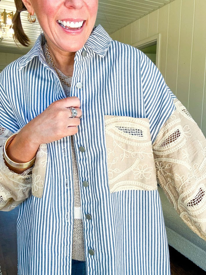 White and denim striped long sleeved shacket with silver button front, collar and taupe and lace sleeves and front pocket.