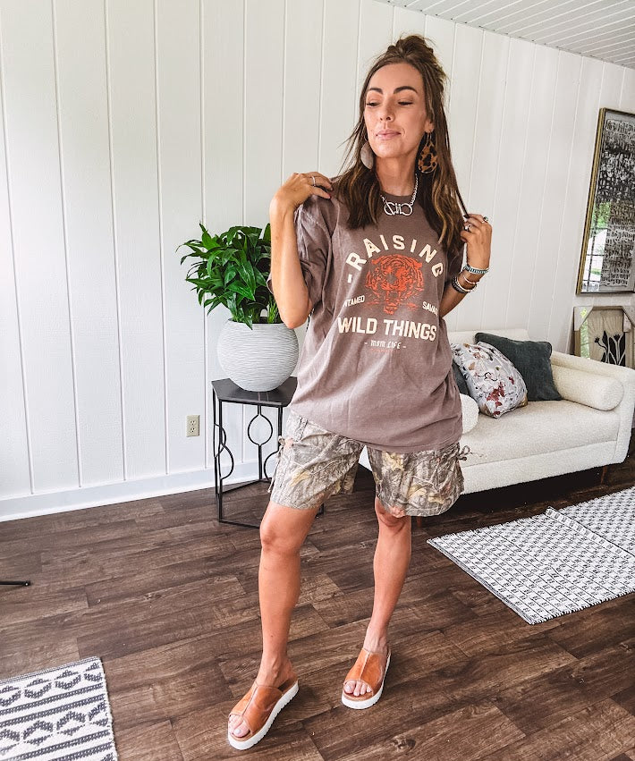 Soft brown cotton tee that celebrates the beautiful chaos of motherhood with cream and orange "Raising Untamed Savage Wild Things - Mom Life" graphics and a bold tiger motif.