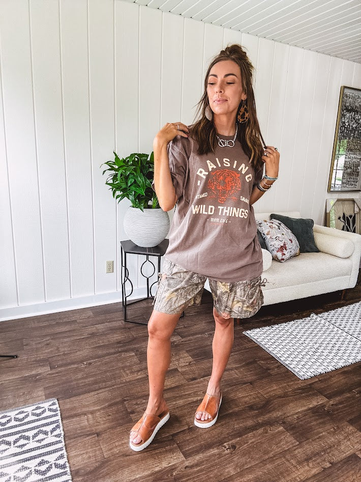 Soft brown cotton tee that celebrates the beautiful chaos of motherhood with cream and orange "Raising Untamed Savage Wild Things - Mom Life" graphics and a bold tiger motif.
