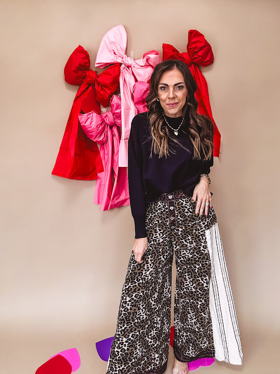Cotton wide leg pants in a dark chocolate, white and black leo print with a white and black wide stripe panel down the side with button fly.