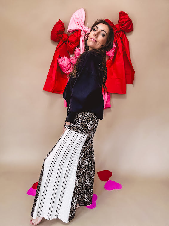 Cotton wide leg pants in a dark chocolate, white and black leo print with a white and black wide stripe panel down the side with button fly.