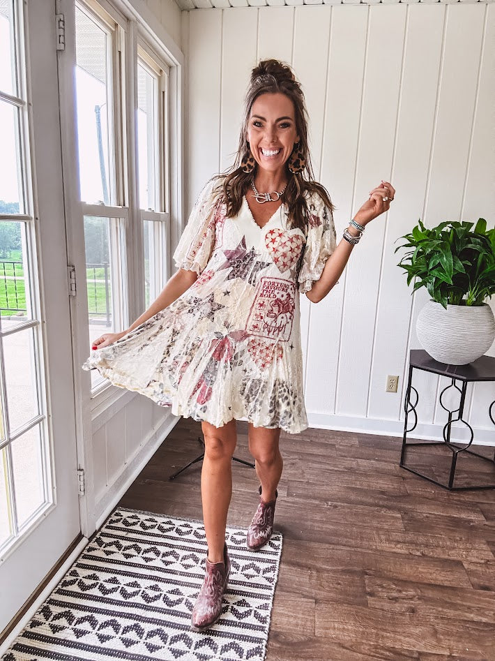 Cream V-neck mini dress with red, taupe, and leopard hearts and stars, lace overlay, ruffled puff sleeves, and an elastic hem. The stretchy, flowy silhouette flatters and flows.