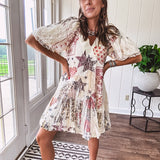Cream V-neck mini dress with red, taupe, and leopard hearts and stars, lace overlay, ruffled puff sleeves, and an elastic hem. The stretchy, flowy silhouette flatters and flows.